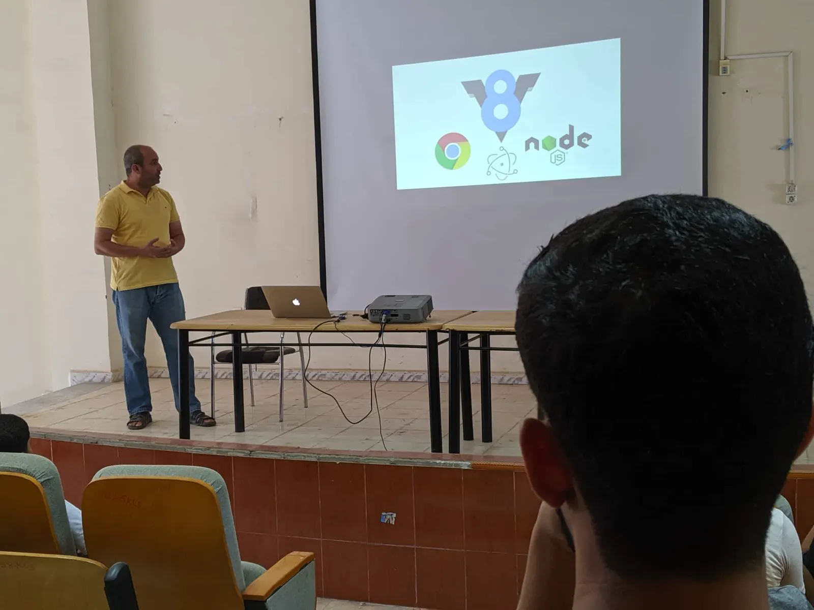 Presenting on stage in front of a projected code slide at GDG I/O Extended, 2017.